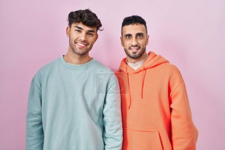 Téléchargez les photos : Young hispanic gay couple standing over pink background with a happy and cool smile on face. lucky person. - en image libre de droit