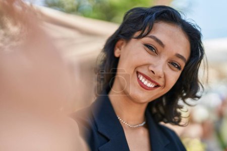 Téléchargez les photos : Jeune belle femme hispanique souriant confiant faire selfie par caméra au parc - en image libre de droit