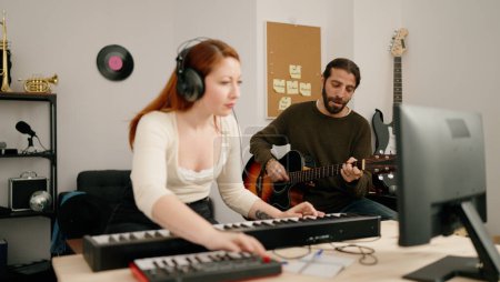 Téléchargez les photos : Homme et femme jouant de la guitare et du piano à clavier au studio de musique - en image libre de droit