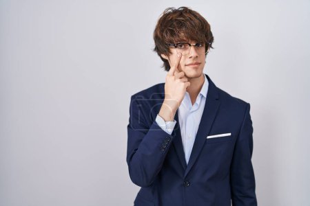 Photo for Hispanic business young man wearing glasses pointing to the eye watching you gesture, suspicious expression - Royalty Free Image