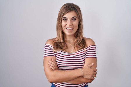 Téléchargez les photos : Jeune femme hispanique debout sur fond isolé heureux visage souriant avec les bras croisés regardant la caméra. personne positive. - en image libre de droit