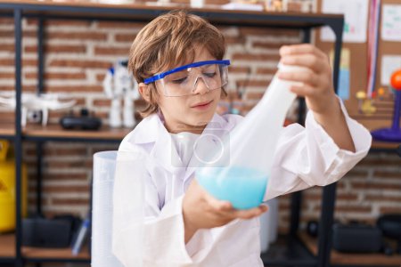 Photo for Adorable caucasian boy student holding test tube at classroom - Royalty Free Image