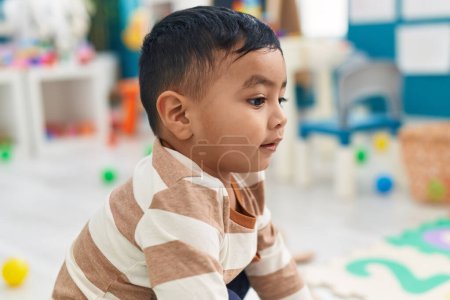 Photo for Adorable hispanic toddler smiling confident sitting on floor at kindergarten - Royalty Free Image