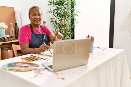 Téléchargez les photos : Femme afro-américaine senior ayant cours de dessin en ligne au studio d'art - en image libre de droit