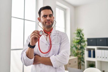 Téléchargez les photos : Young hispanic doctor man with beard holding stethoscope auscultating skeptic and nervous, frowning upset because of problem. negative person. - en image libre de droit