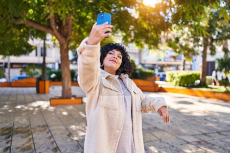 Photo for Young beautiful hispanic woman smiling confident making selfie by the smartphone at park - Royalty Free Image