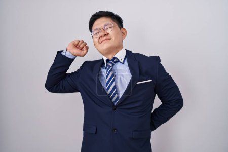 Photo for Young asian man wearing business suit and tie stretching back, tired and relaxed, sleepy and yawning for early morning - Royalty Free Image