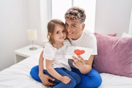 Photo for Father and daughter father and daughter hugging each other holding heart draw at bedroom - Royalty Free Image