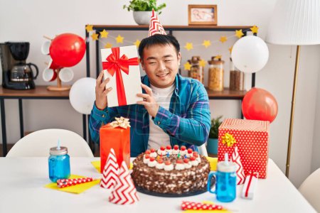 Foto de Joven chino hombre celebrando cumpleaños celebración regalo en casa - Imagen libre de derechos