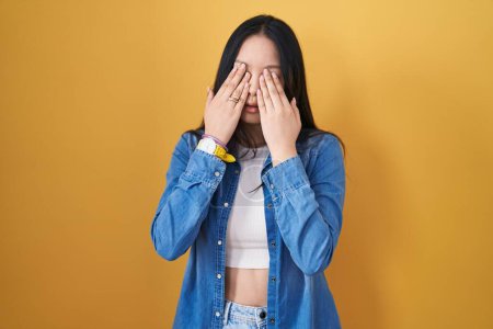 Téléchargez les photos : Young asian woman standing over yellow background rubbing eyes for fatigue and headache, sleepy and tired expression. vision problem - en image libre de droit