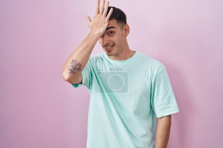 Photo for Handsome hispanic man standing over pink background surprised with hand on head for mistake, remember error. forgot, bad memory concept. - Royalty Free Image