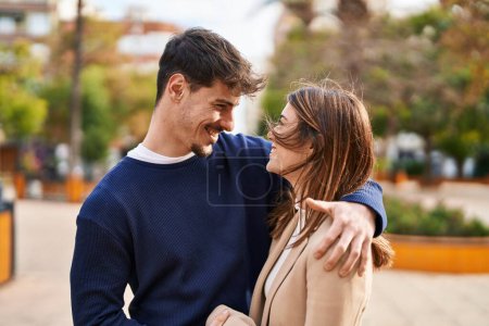 Téléchargez les photos : Mand and woman couple hugging each other at park - en image libre de droit