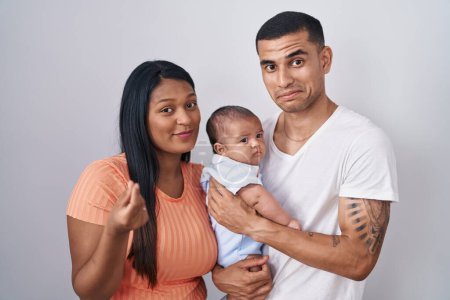 Photo for Young hispanic couple with baby standing together over isolated background doing money gesture with hands, asking for salary payment, millionaire business - Royalty Free Image