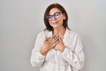 Photo for Middle age hispanic woman standing over isolated background smiling with hands on chest with closed eyes and grateful gesture on face. health concept. - Royalty Free Image