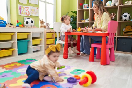 Photo for Teacher with girls playing at kindergarten - Royalty Free Image