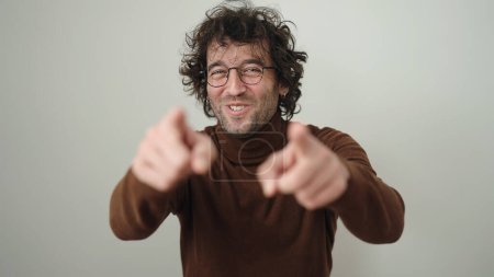 Téléchargez les photos : Jeune homme hispanique souriant confiant pointant avec les doigts sur fond blanc isolé - en image libre de droit