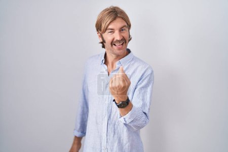 Foto de Caucasian man with mustache standing over white background beckoning come here gesture with hand inviting welcoming happy and smiling - Imagen libre de derechos