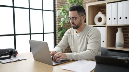 Téléchargez les photos : Young hispanic man business worker using laptop working at office - en image libre de droit