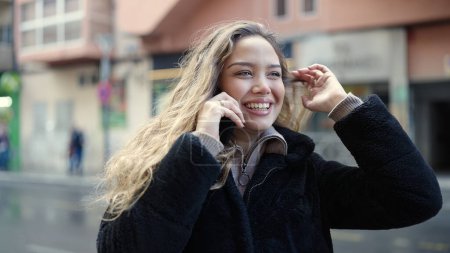 Téléchargez les photos : Jeune belle femme hispanique souriant confiant parler sur smartphone à la rue - en image libre de droit