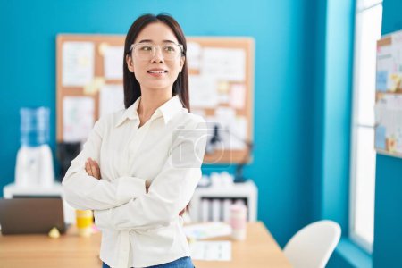Photo for Young chinese woman business worker smiling confident standing with arms crossed gesture at office - Royalty Free Image