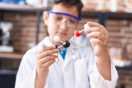 Foto de Adorable estudiante hispano buscando moléculas en el aula de laboratorio - Imagen libre de derechos
