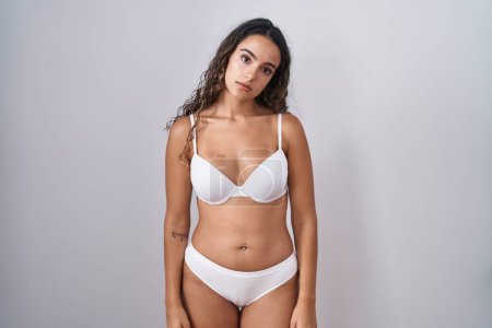 Photo for Young hispanic woman wearing white lingerie looking sleepy and tired, exhausted for fatigue and hangover, lazy eyes in the morning. - Royalty Free Image