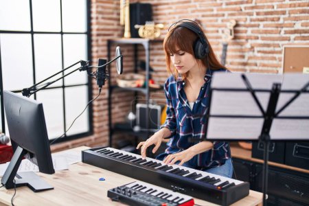 Photo for Young woman musician playing piano keyboard at music studio - Royalty Free Image