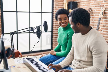 Foto de Hombre y mujer afroamericanos grupo de música cantando canción tocando el piano del teclado en el estudio de música - Imagen libre de derechos