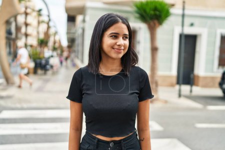 Téléchargez les photos : Jeune femme latine souriante confiante debout dans la rue - en image libre de droit