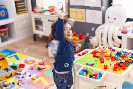 Photo for Adorable hispanic toddler playing with construction blocks and bubbles at kindergarten - Royalty Free Image