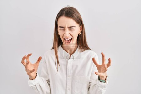 Photo for Young caucasian woman standing over isolated background crazy and mad shouting and yelling with aggressive expression and arms raised. frustration concept. - Royalty Free Image