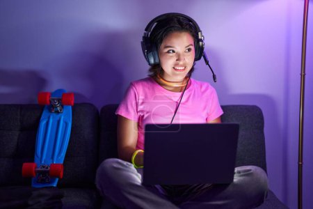 Photo for Young hispanic woman streamer smiling confident holding headphones at home - Royalty Free Image