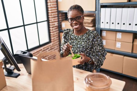 Téléchargez les photos : Femme afro-américaine ecommerce travailleur d'affaires manger de la salade au bureau - en image libre de droit