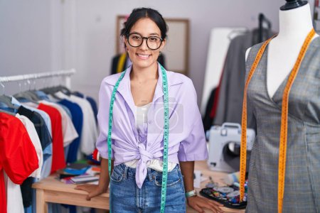 Téléchargez les photos : Jeune belle femme hispanique tailleur souriant confiance debout au magasin de tailleur - en image libre de droit