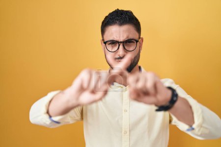 Téléchargez les photos : Jeune homme hispanique portant des vêtements d'affaires et lunettes expression de rejet croisant les doigts faisant signe négatif - en image libre de droit
