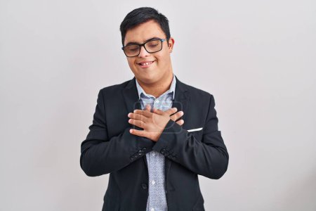 Photo for Young hispanic man with down syndrome wearing business style smiling with hands on chest with closed eyes and grateful gesture on face. health concept. - Royalty Free Image
