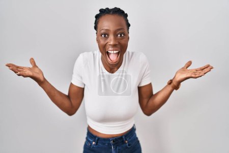 Photo for Beautiful black woman standing over isolated background celebrating crazy and amazed for success with arms raised and open eyes screaming excited. winner concept - Royalty Free Image