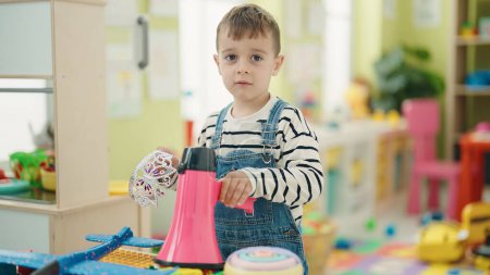Photo for Adorable caucasian boy holding megaphone standing at kindergarten - Royalty Free Image