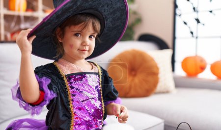 Téléchargez les photos : Adorable fille hispanique souriant avec confiance porter costume d'Halloween à la maison - en image libre de droit