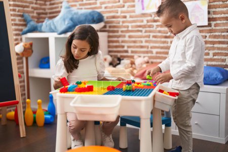 Photo for Brother and sister playing with construction blocks standing at kindergarten - Royalty Free Image
