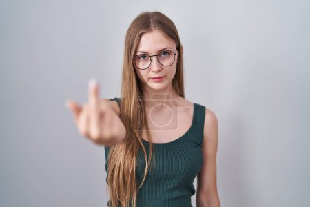 Téléchargez les photos : Young caucasian woman standing over white background showing middle finger, impolite and rude fuck off expression - en image libre de droit