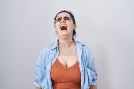 Téléchargez les photos : Young modern girl with blue hair standing over white background angry and mad screaming frustrated and furious, shouting with anger. rage and aggressive concept. - en image libre de droit