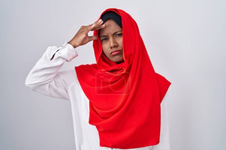 Photo for Young arab woman wearing traditional islamic hijab scarf worried and stressed about a problem with hand on forehead, nervous and anxious for crisis - Royalty Free Image