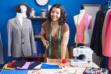 Téléchargez les photos : Jeune femme tailleur tissu de coupe au studio de couture - en image libre de droit