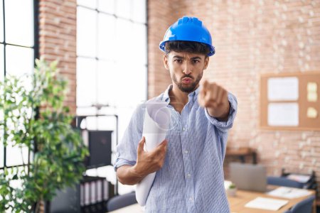 Téléchargez les photos : Arab man with beard wearing architect hardhat at construction office pointing with finger to the camera and to you, confident gesture looking serious - en image libre de droit