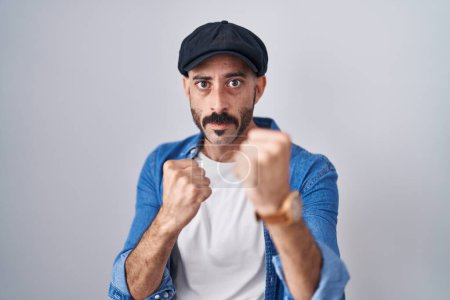 Photo for Hispanic man with beard standing over isolated background ready to fight with fist defense gesture, angry and upset face, afraid of problem - Royalty Free Image