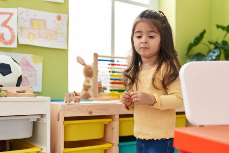 Photo for Adorable hispanic girl standing with relaxed expression at kindergarten - Royalty Free Image