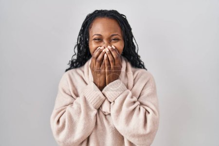Foto de African woman standing over white background laughing and embarrassed giggle covering mouth with hands, gossip and scandal concept - Imagen libre de derechos