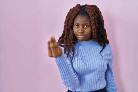 Foto de Mujer africana de pie sobre fondo rosa haciendo gesto italiano con la mano y los dedos expresión de confianza - Imagen libre de derechos