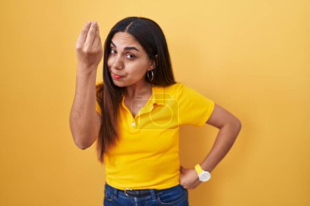 Téléchargez les photos : Young arab woman standing over yellow background doing italian gesture with hand and fingers confident expression - en image libre de droit